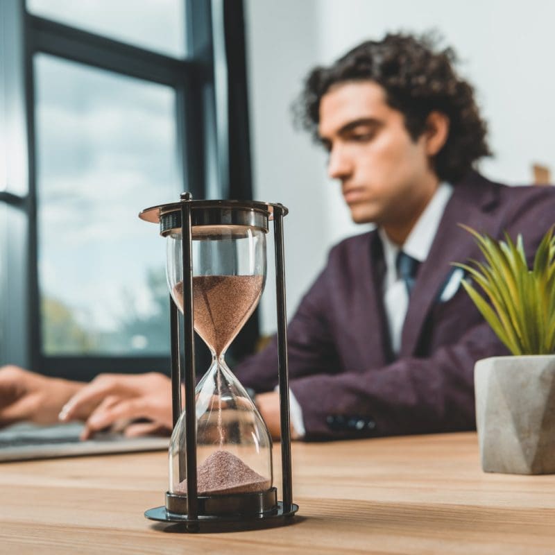 selective focus of businessman typing on laptop while struggling to meet deadlines
